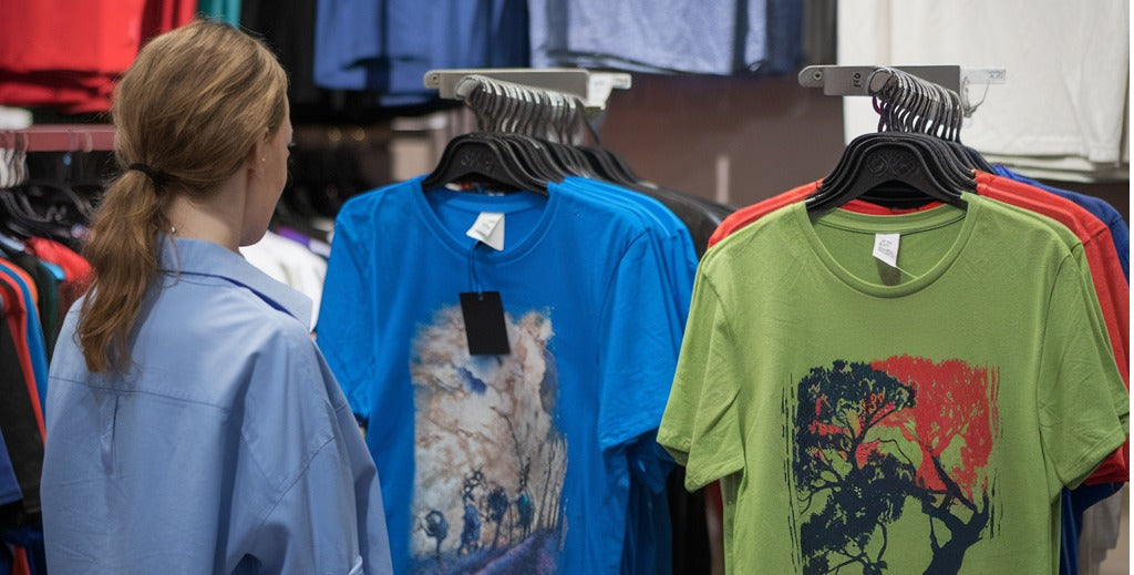 woman looking at t-shirts with dtf transfers on them
