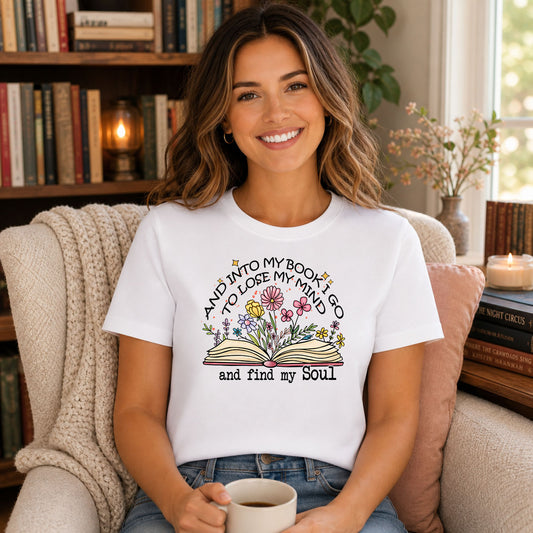 And Into My Book I Go DTF transfer mockup on a t-shirt featuring an open book with wildflowers and an inspirational arched quote