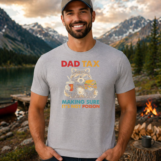 Dad Tax DTF transfer design mockup on a t-shirt featuring a cartoon raccoon eating a hamburger with red DAD TAX and Making Sure It's Not Poison subtitle