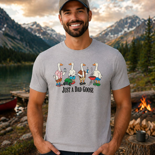 Just A Dad Goose DTF transfer design mockup on a t-shirt featuring three cartoon geese in dad gear including BBQ apron, swim trunks and beach attire with Just A Dad Goose text