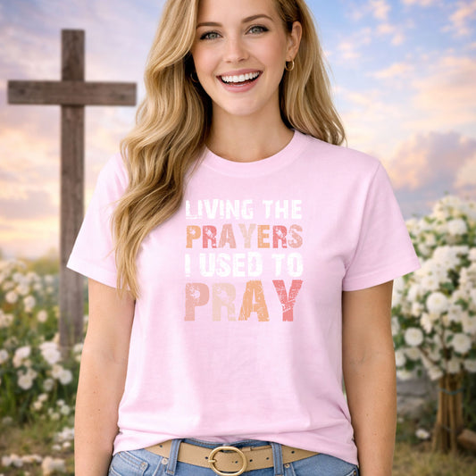 Living The Prayers DTF transfer design mockup on a t-shirt featuring Living The Prayers I Used To Pray typography in warm earth tones