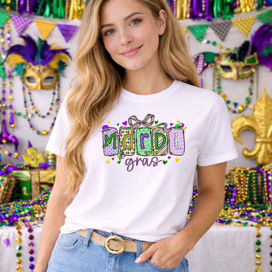 Mardi Gras Vibrant DTF transfer design mockup on a t-shirt featuring bold vibrant MARDI GRAS block letters with cursive Gras in purple green and gold