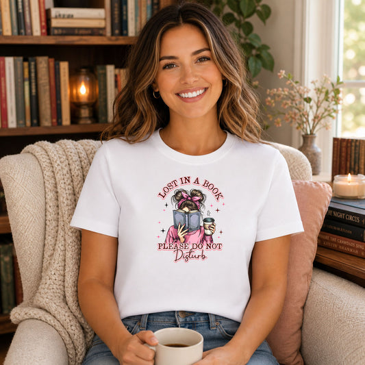 Messy Buns Lost In A Book DTF transfer design mockup on a t-shirt featuring a woman with messy bun reading a book with coffee and Lost In A Book Please Do Not Disturb text
